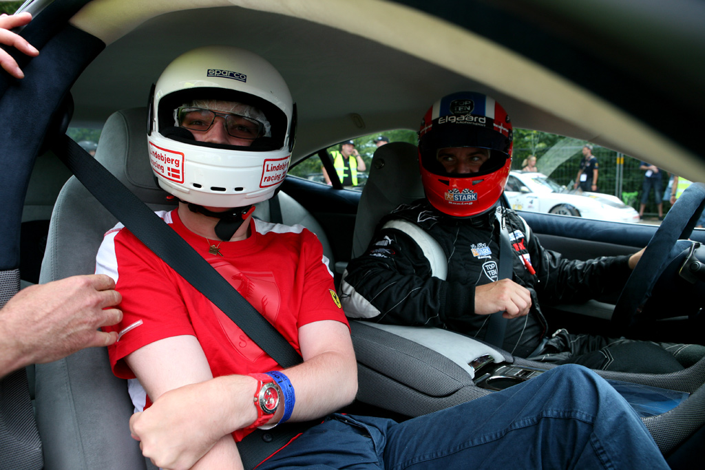 Den populære Casper Elgaard er ved at give handikappet ung fyr en tur for livet i den smukke Fisker Karma. Motorsporten.dk kan fortælle af den unge fyr samt hans bror og mor er trofaste gæster ved CHGP.
(Foto: Motorsporten.dk)